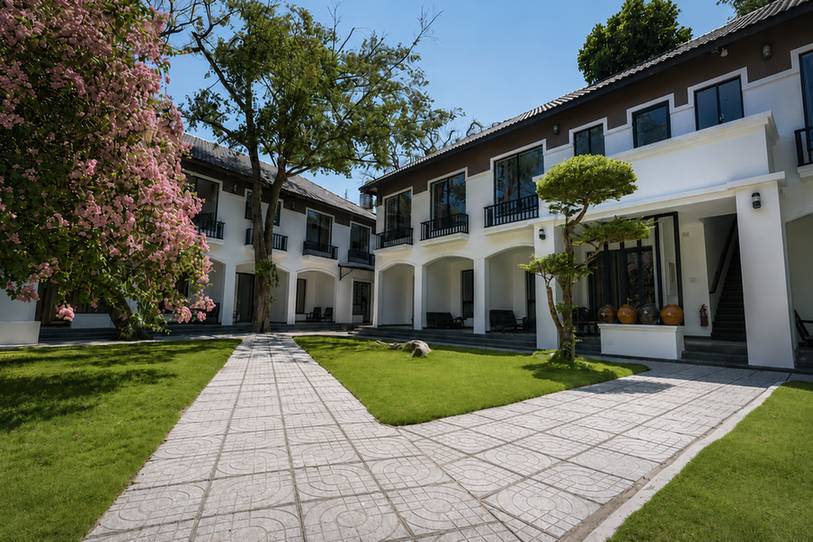 Lối đi đá rợp bóng dừa trong khu vườn Ven Ven Hotel tại Hồ Cốc